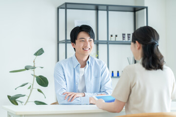 メンズエステに美容の相談する若い男性