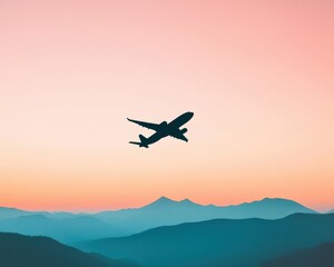 Airplane flying over a mountain range as the first light of sunrise breaks the horizon