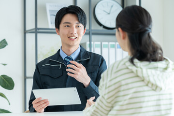 若い女性に営業する工務店の若い男性