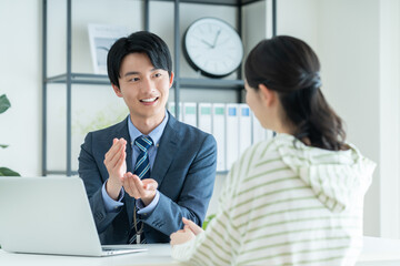 若い女性に提案するプランナーの男性