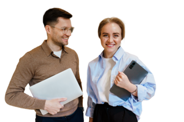 Young professionals smiling while holding laptops in a bright workspace