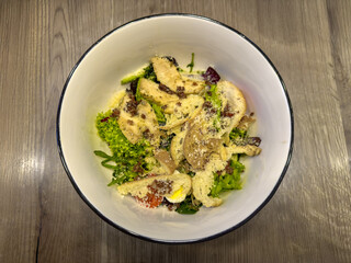 Fresh Caesar salad with homemade croutons in white bowl. Healthy green salad with crispy croutons and parmesan