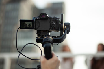 Professional video camera mounted on a stabilizer capturing outdoor scenes.