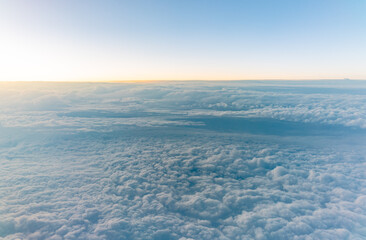 Beautiful orange and pink sunrise over the clouds, view from the plane.