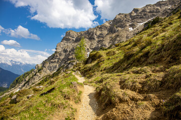 Austria Alps mountain landscape in early summer with snow, grass and rocky summits on a sunny day. Austrian mountains beautiful scenic view in Tirol near Imst