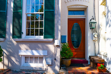 Red door with festive decoration. Cozy entrance to the house from the street.