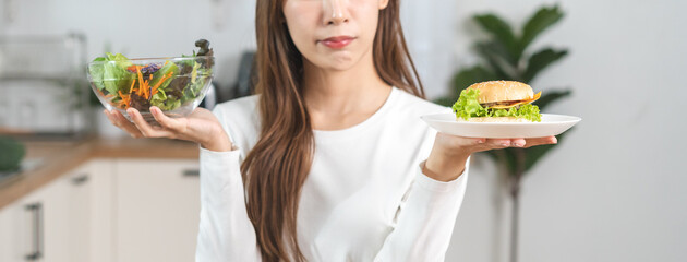 Diet, Dieting asian young woman, girl confused choose, choice eating food, hand holding bowl of...
