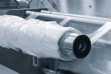 Automatic polyethylene plastic bag production machine with lighting effect. Close-up of the roller...