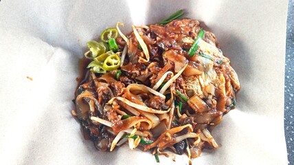 Close up char kue tiaw. Famous Malaysian dish contain flat noodles, thick shrimp sauce, shrimp, cockles and bean sprout.