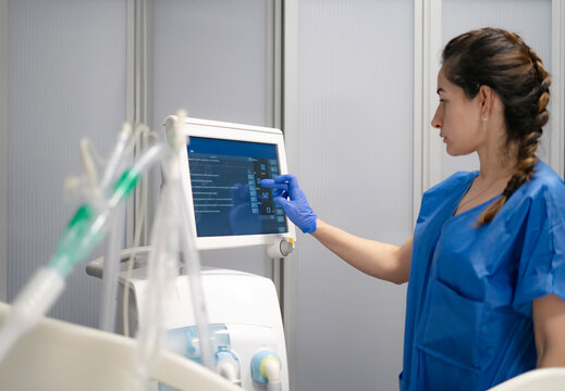 Doctor using touch screen on medical equipment in clinic