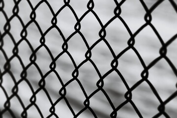 Naklejka premium A classic black and white image of a chain link fence, perfect for use in various settings where a simple border or barrier is needed.