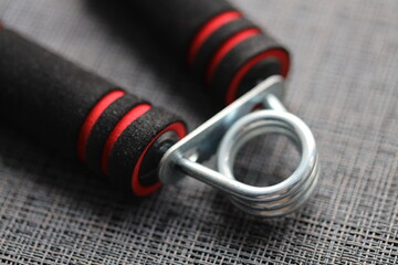 A pair of industrial-style handles with black and red colors on a gray background.