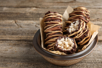 Delicious chocolate puffed rice bars on wooden table, closeup