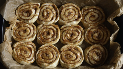 Placing cinnamon rolls in the baking pan.