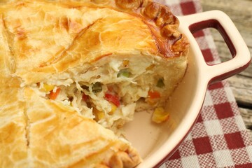 Tasty homemade pie with chicken and vegetables in baking dish on table, closeup