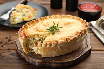 Delicious fresh homemade pie with rosemary on wooden table, closeup