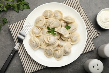 Delicious dumplings served on grey table, flat lay