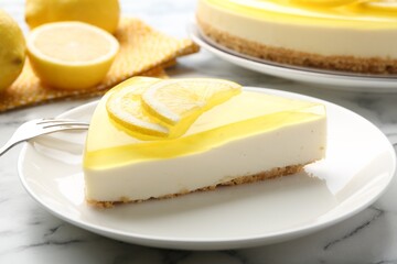 Piece of tasty lemon cheesecake and fork on white marble table, closeup