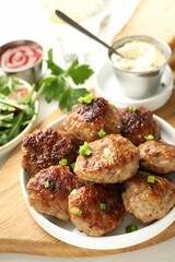 Delicious patties with green onions served on table, closeup