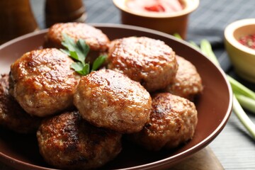 Delicious patties with parsley on table, closeup