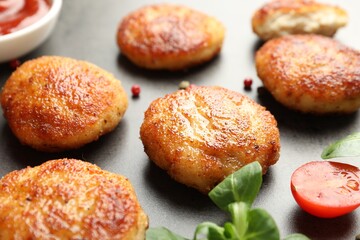 Tasty patties, spinach and tomato on grey textured table, closeup