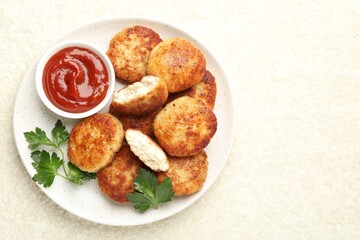 Tasty patties, parsley and ketchup on light textured table, top view. Space for text