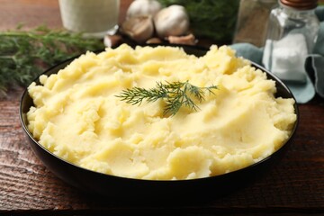 Delicious mashed potato with dill served on wooden table, closeup