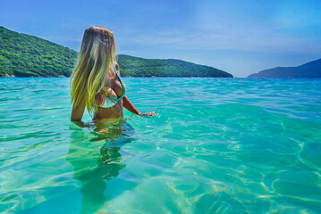 Beautiful woman in the crystal clear waters of Forno Beach in Arraial do Cabo City. RJ, Brazil, Feb...