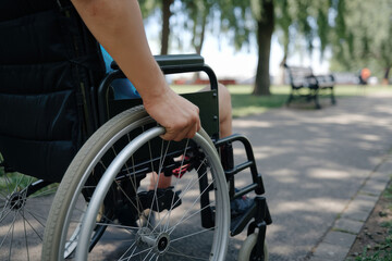 Obraz premium Young adult using a wheelchair on a park pathway, showcasing mobility and independence in an accessible environment
