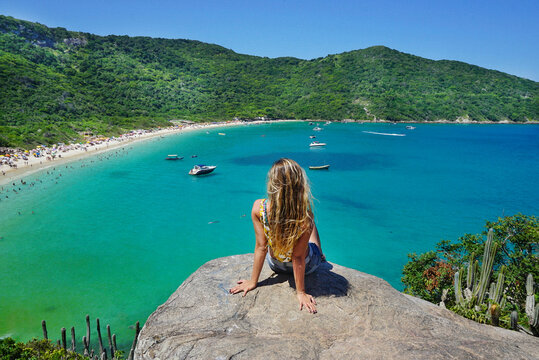 Beautiful woman contemplating the beauty of the Forno Beach, and its crystal clear waters. Arraial do Cabo City, RJ, Brazil, Feb 2020