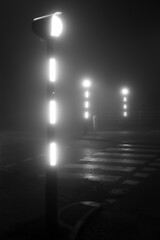 Belisha beacons on a road crossing, pedestrian crossing or crosswalk on a foggy night