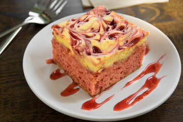 Square shape strawberry cheese cake on white dish.