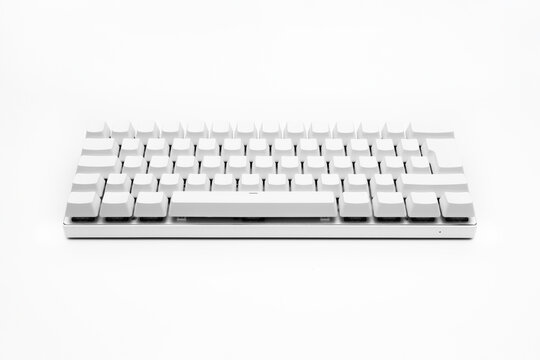 Blank white keyboard. Wireless gaming mechanical computer keyboard closeup, isolated. Minimal, modern design on white background. front view. 60 percent keyboard. copy space. Communication device.