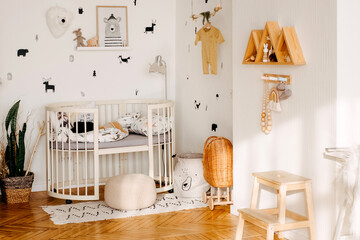 Nursery room with baby decorations toys and white walls. White child room interior for mockup, interior design. Decorative baby room wooden detail and baby interior.
Bright scandinavian baby room