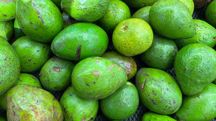 Fresh Green Avocados Piled Together in a Market Setting