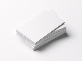 Minimalist product photography of stacked blank business cards on white office surface