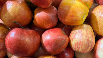 Freshly Harvested Apples Piled Together at a Local Market Showcasing Vibrant Colors and Textures on a Sunny Day