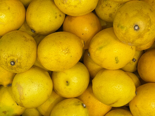Fresh Lemons Piled High in a Market, Showcasing Vibrant Yellow Color and Natural Imperfections