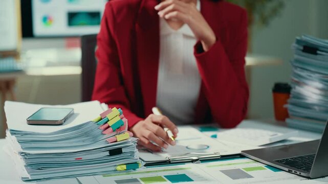 Professional businesswoman examining financial reports, analyzing sales data through charts and graphs at sleek corporate workspace