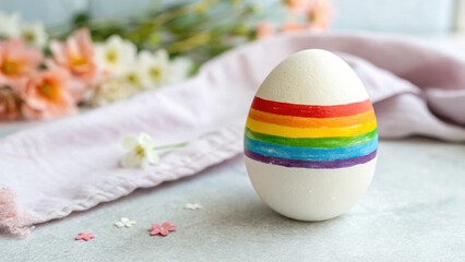 Easter Egg rainbow. Colorful rainbow-striped egg with flowers in a soft setting.