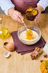 Step by step preparation of dough for pumpkin donuts. Adding pumpkin puree to milk mixture for dough. Dishes pumpkin.