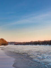 Beautiful, serene landscape with a frozen river and a clear blue sky