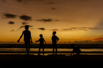 Silhouette of Children Playing on the Beach at Sunset