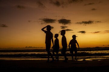 Silhouettes of Children Playing on the Beach at Sunset