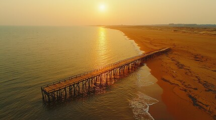 Obraz premium Wooden pier at sunset over beach