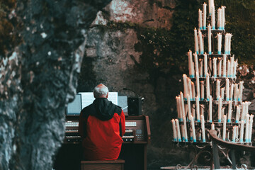 Organist Playing in Stone Church with Candles