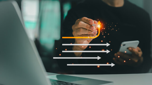 In this business management concept, a businessman erases a white arrow and draws a yellow arrow, symbolizing a strategic shift toward innovation and growth.