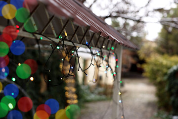 Canopy decorated with Christmas lights outdoors, closeup. Space for text