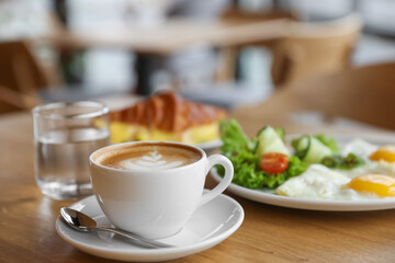 Delicious breakfast served on wooden table in cafe, closeup