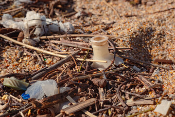 Plastic trash on the beach. Pollution of the environment with plastic. Ocean beach polluted with waste. Close-up photo
